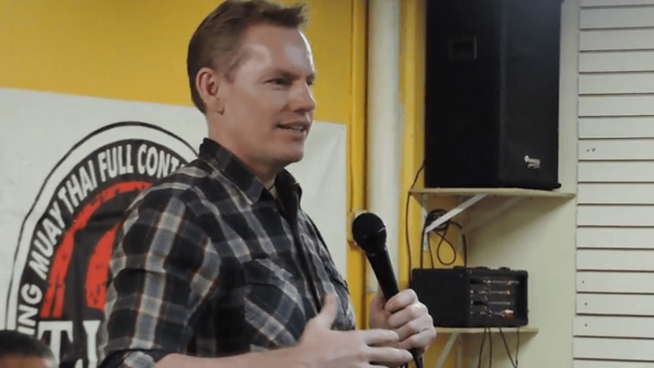 Rick Tew speaking with a microphone