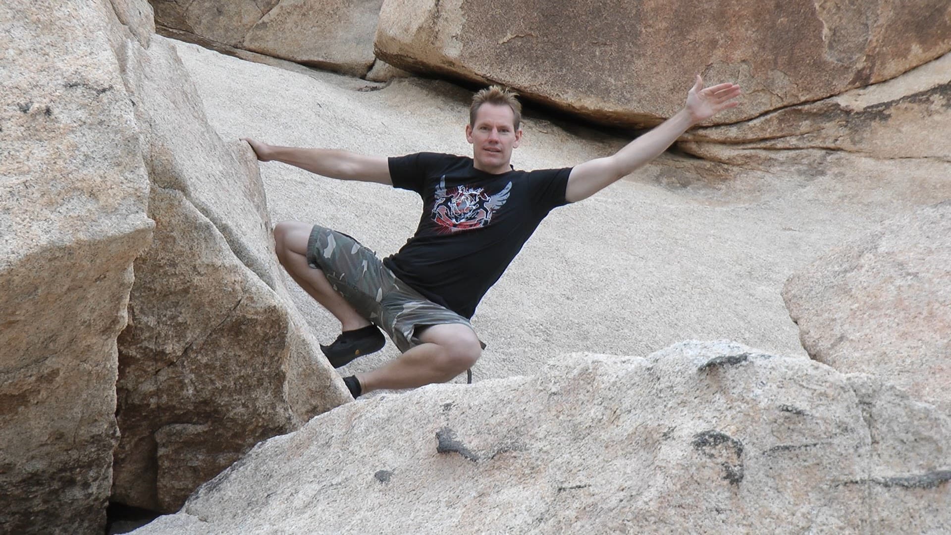Rick Tew stretching between rocks