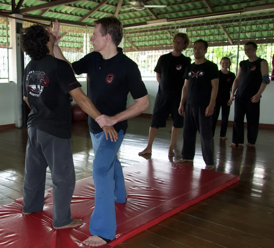 Rick Tew shows a wrist control on a student while a row of adults watches
