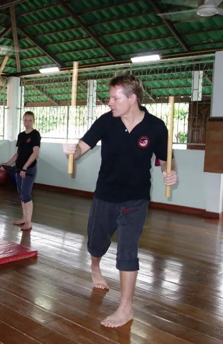 A student steps through a stance drill in an open-air hall