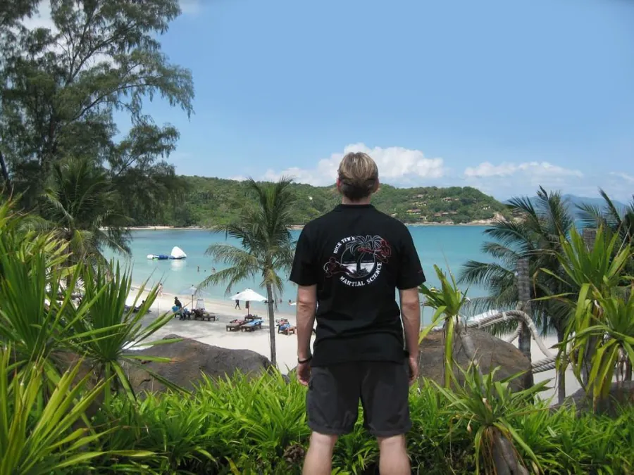 A student looks out over a tropical beach