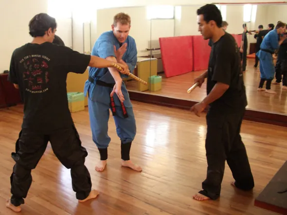 Students drill an arm control in a mirrored dojo