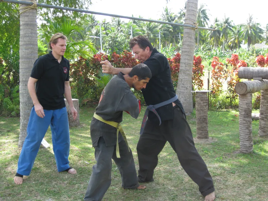 Two students work a clinch on a lawn while Rick Tew watches