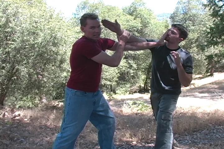 Rick Tew blocks a punch and checks the arm in a pine forest