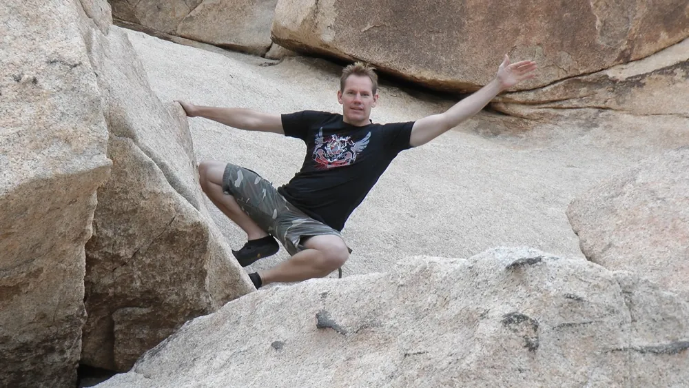 Rick Tew leaping between boulders